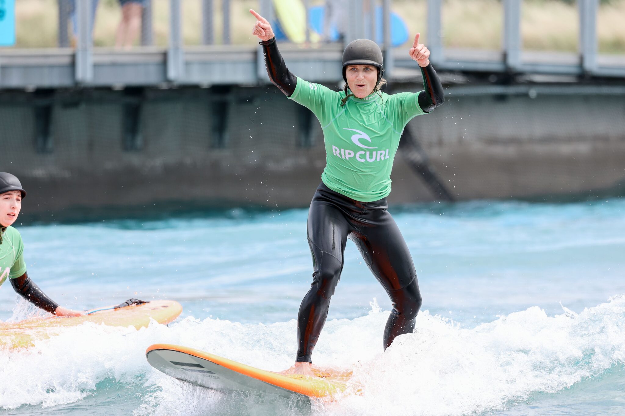 Female surfer celebrates catching a wave.