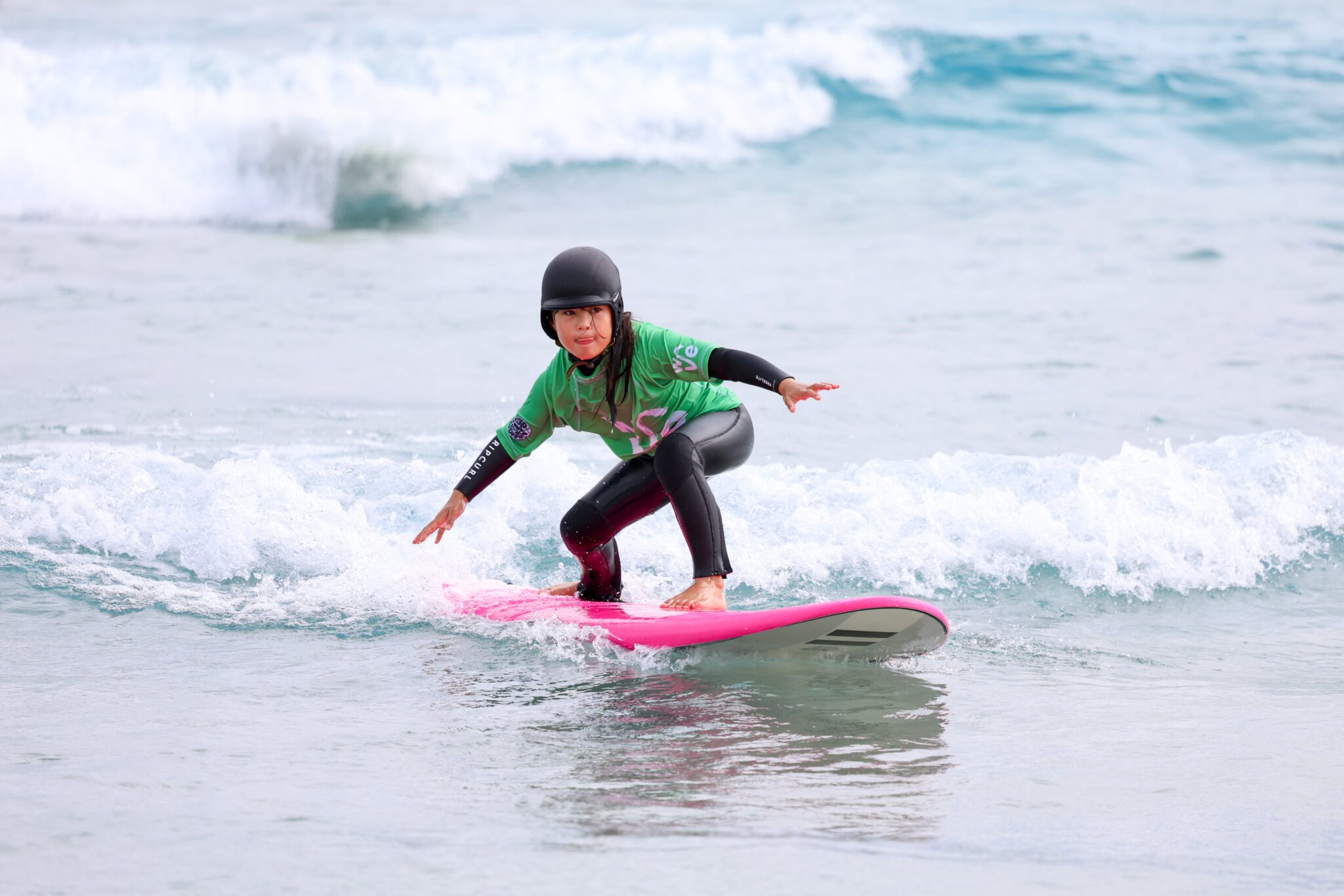 child learns to surf in a little rippers lesson at the wave inland surf lake near bristol